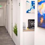 Office hallway at eDental Perth with decorative paintings hanging on the white-painted wall.