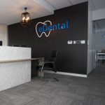 An office with a wall painted in black and it has eDental Perth logo on it.