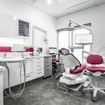 eDental Perth clinic. It has tables, a red dental chair, monitor screen that shows its logo and other tools to be used for dental procedures.