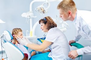 2 dental nurses looking on a girl's teeth and as the header image of 