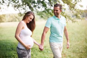 Pregnant wife with her husband smiling and walking, and as the header image of 