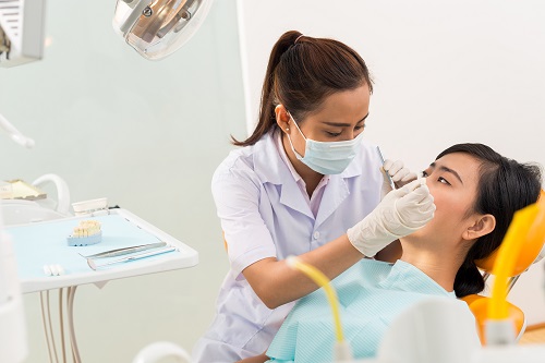 A female dentist examining a patient, and that represents the 