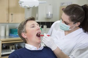A dentist checking the teeth of the patient and as the header image of 