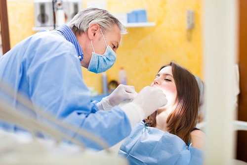 Dentist checking the mouth of his patient and that represents the 