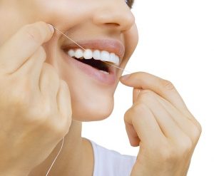 Woman flossing her teeth and as the header image of 
