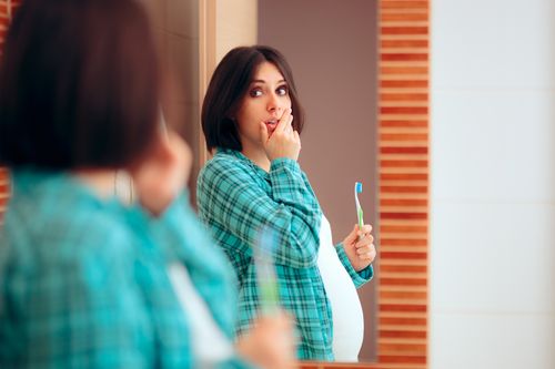 Woman on a mirror checking her teeth using 