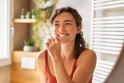 Woman brushing her teeth, and represents the 